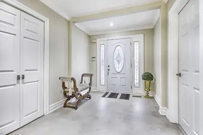 an empty hallway with a chair in front of a door at 5 Bedroom Vacation Cottage - King City in Schomberg
