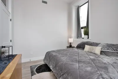 a white bedroom with a large bed and a window at The National on Queen in Saint Marys