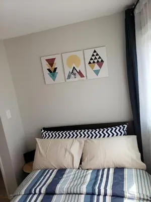 a bedroom with a bed and some pictures on the wall at 2plex, Choose, 1of 2 entire units apparts in Hamilton
