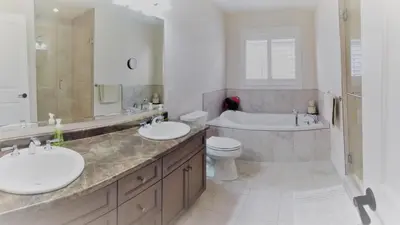 a bathroom with two sinks and a tub and a toilet at Executive House easy access to Kitchener-Waterloo, Cambridge, Toronto, walk to restaurants in Kitchener