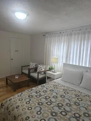 a bedroom with a large bed and a living room at 3-Bed 3-Bath Cozy Vacation House in Ajax, Greater Toronto Area, ON, Canada in Ajax
