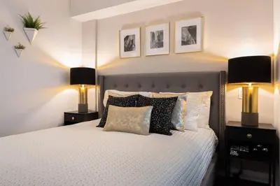 a bedroom with a bed with two lamps on it at Yorkville Living 1 BR-1BA with Gym in Upscale Area in Toronto