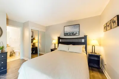 a bedroom with a large white bed and two lamps at Condo 208 At North Creek Resort in Blue Mountains