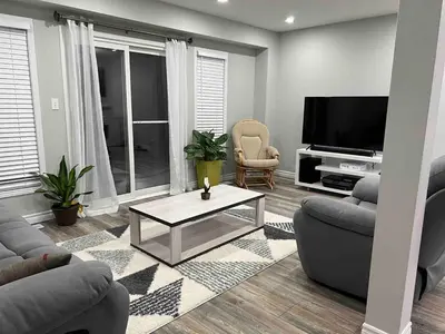 a living room with two couches and a television at The Hestia Kitchener in Kitchener