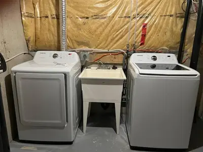 two washing machines and a sink in a room at The Hestia Kitchener in Kitchener