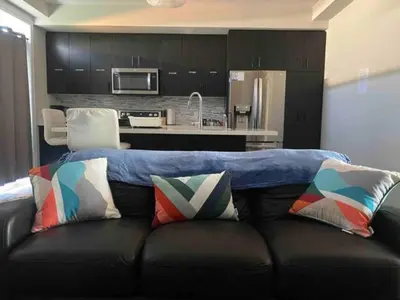a couch with a blue blanket on top of it at Poise Homes Guest Home Cambridge in Cambridge
