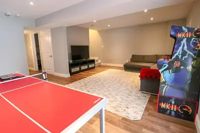 a living room with a ping pong table and a couch at Impressive Modern Waterfront Home on Georgian Bay in Port McNicoll