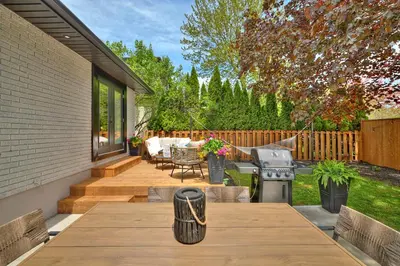 a backyard with a wooden table and a grill at The Newark House in Niagara on the Lake