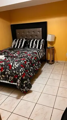 a bedroom with a bed with a black and red comforter at Cozy private room in Brampton