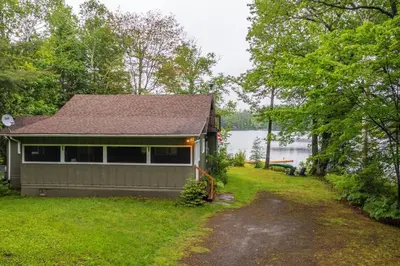 a house on the shore of a lake at Bear Essentials Hideaway in Huntsville