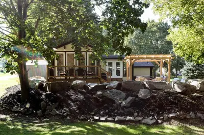 a house with a rock wall in front of a house at Disconnect From Reality/ River House/Hot Tub/Pet Friendly in Port Burwell