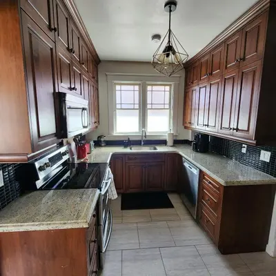 a large kitchen with wooden cabinets and a sink at The Pandora Century Home in Kitchener