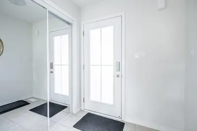 a white room with two doors and a mirror at GlobalStay 3 Bedroom Townhouse Near Niagara Falls Brock University in Thorold