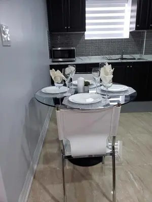 a table with two plates and glasses on it in a kitchen at Luxurious Apt 2BRs-1BA Spacious Modern, with free parking in Brampton