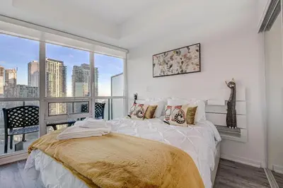 a bedroom with a bed and a large window at Stunning 2 BD in heart of Toronto with Parking in Toronto