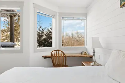 a white bedroom with a bed and two windows at Collingwood Chalet Near Blue Mountain Slopes 39A in Collingwood