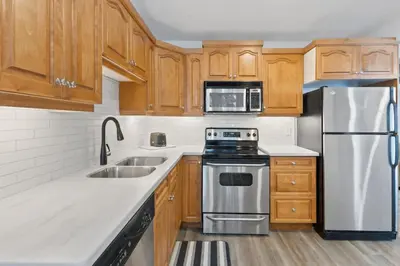a kitchen with wooden cabinets and stainless steel appliances at Collingwood Chalet Near Blue Mountain Slopes 39A in Collingwood