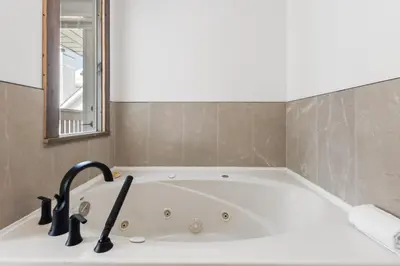 a bath tub with a sink and a mirror at Collingwood Chalet Near Blue Mountain Slopes 39B in Collingwood