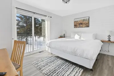 a white bedroom with a bed and a balcony at Collingwood Chalet Near Blue Mountain Slopes 39B in Collingwood
