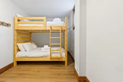 a bunk bed room with two bunk beds and a ladder at 3 Level Ski Chalet 7BR w Deck, Sauna & Ping-Pong! in Blue Mountains