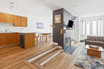 an open kitchen and living room with a fireplace at Blue Mountain Ski In Ski Out Resort Condo 2 Level in Blue Mountains
