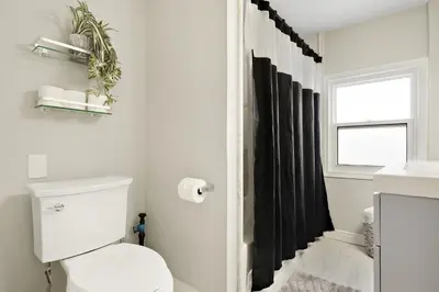 a bathroom with a toilet and a black shower curtain at Separate 3BR Family Friendly Apartments, Separate Floors, 5 Minutes Walk to The Fallsview with Free Parking & Wine in Niagara Falls