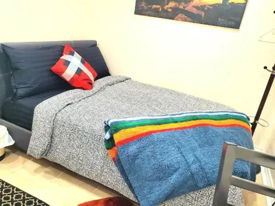 a bedroom with a bed with a rainbow blanket on it at Cozy & Convenient Studio Apartment in Pickering