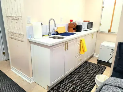 a kitchen with a sink and a microwave at Cozy & Convenient Studio Apartment in Pickering
