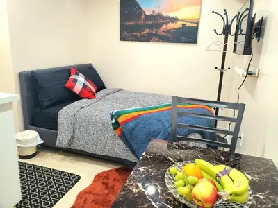 a living room with a couch and a bowl of fruit on a table at Cozy & Convenient Studio Apartment in Pickering