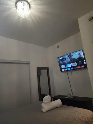 a bedroom with a bed and a flat screen tv on the wall at Beautiful Townhouse Near Yorkdale Mall, Wilson Subway in Toronto