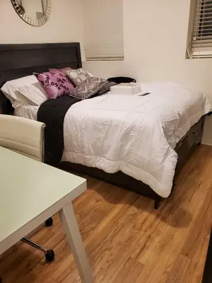 a bedroom with a bed with white sheets and pink pillows at Beautiful Townhouse Near Yorkdale Mall, Wilson Subway in Toronto