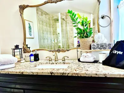 a bathroom counter with a sink and a mirror at Settlers Suites in Niagara on the Lake