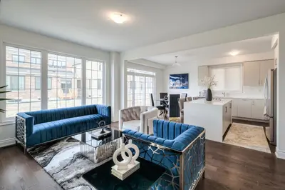 a living room with two blue couches and a kitchen at Masterfully Designed Private Suite in Bradford