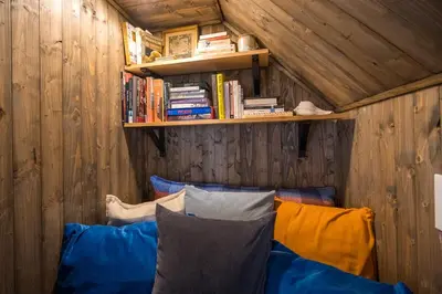 a room with a couch and a shelf with books at Artistic Picton getaway in Picton