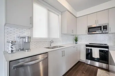 a kitchen with white cabinets and stainless steel appliances at The Ultimate Staycation in Bradford