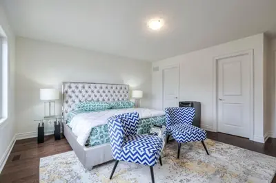a bedroom with a bed and two chairs and a rug at The Ultimate Staycation in Bradford