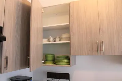 a kitchen cupboard with plates and dishes in it at Modern Town House Barrie South in Barrie